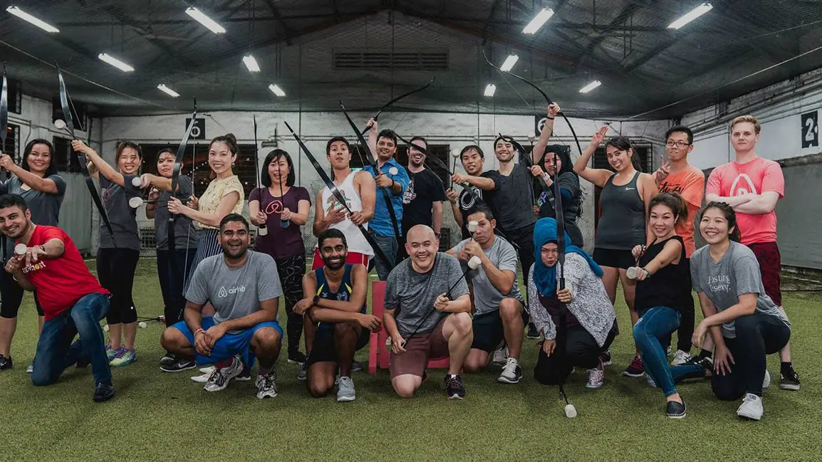 A Cohesion Archery Tag group posing with bows on a covered court