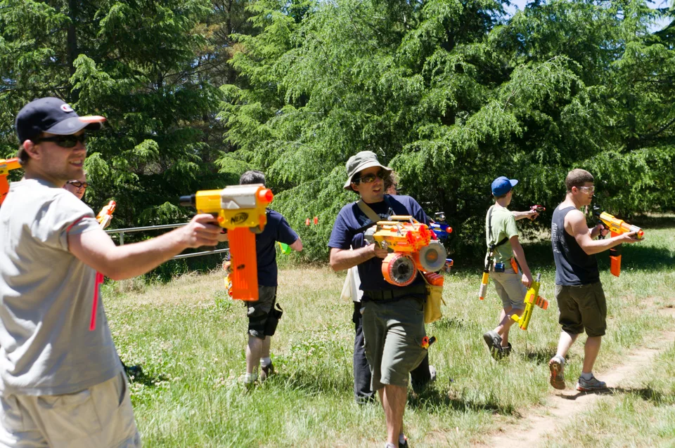 Reference photo of players carrying foam-dart blasters outdoors